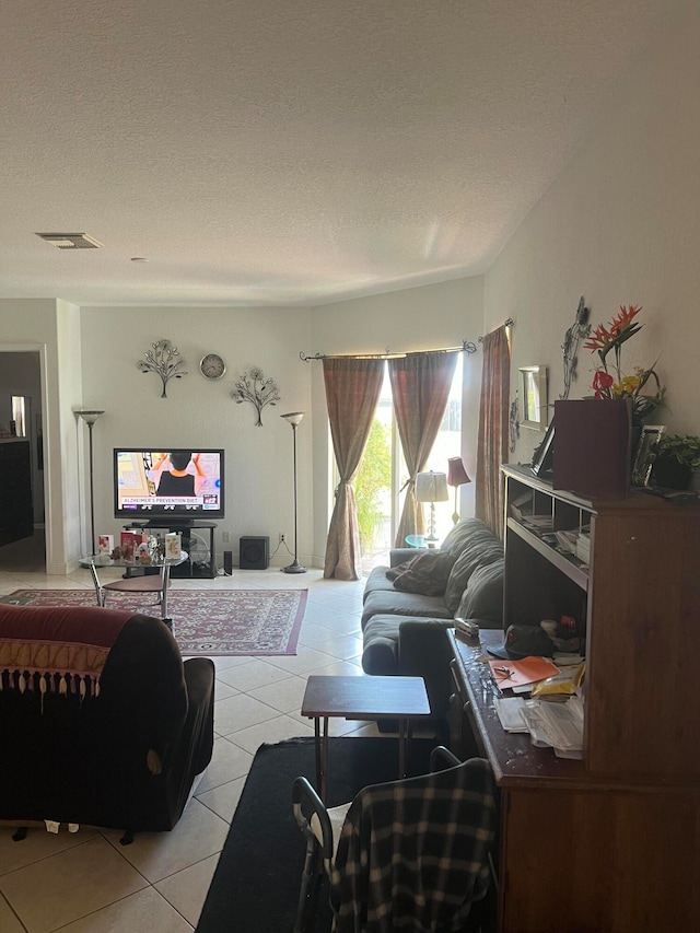 tiled living room featuring a textured ceiling