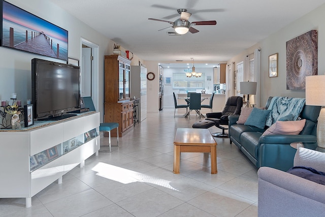 tiled living room with ceiling fan with notable chandelier