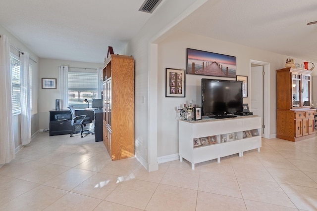 living room with a textured ceiling and light tile patterned flooring