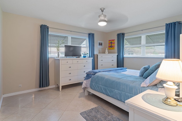 bedroom with multiple windows, ceiling fan, and light tile patterned flooring