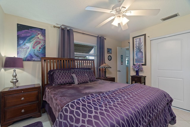 bedroom featuring ceiling fan, a closet, and light tile patterned flooring