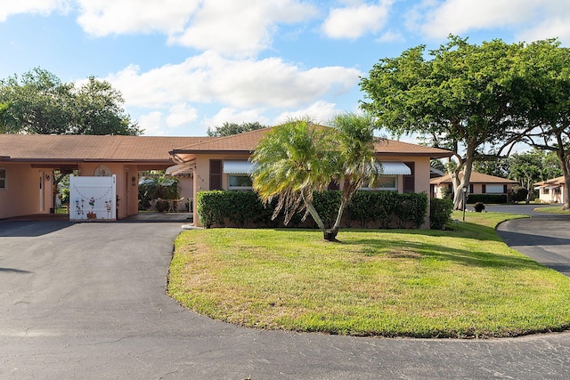 ranch-style house with a front yard and a carport