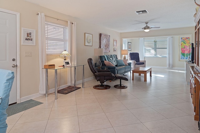 tiled living room with plenty of natural light, ceiling fan, and a textured ceiling