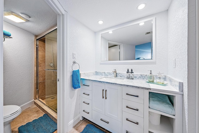 bathroom with walk in shower, toilet, tile flooring, a textured ceiling, and vanity