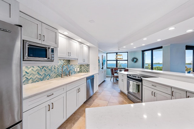 kitchen with stainless steel appliances, tasteful backsplash, white cabinetry, sink, and light tile floors