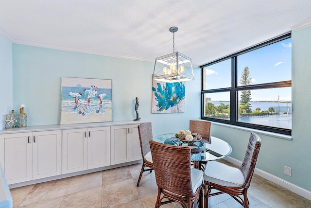 tiled dining area with a water view, a chandelier, crown molding, and a textured ceiling