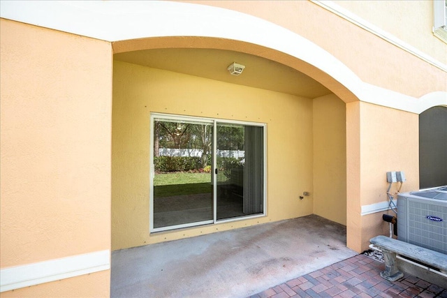 entrance to property featuring a patio and central air condition unit