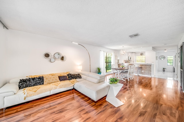 living room with a fireplace, dark wood-type flooring, and a textured ceiling