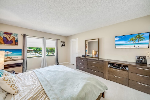 bedroom with light tile floors and a textured ceiling