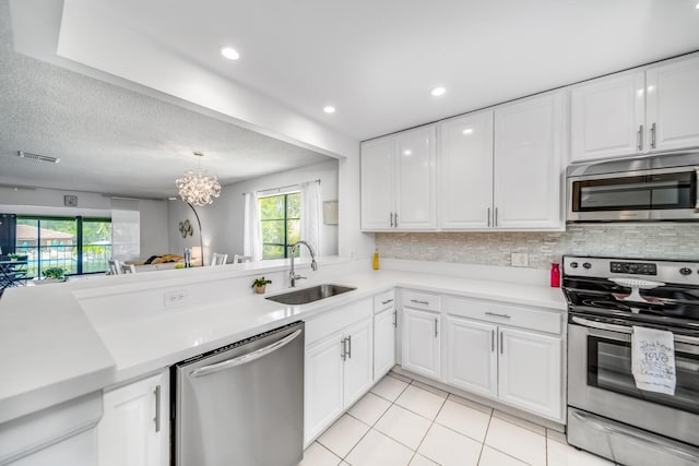 kitchen featuring a breakfast bar, white cabinetry, kitchen peninsula, stainless steel appliances, and tasteful backsplash