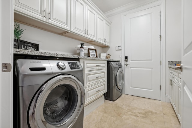 laundry room with washing machine and clothes dryer, crown molding, light tile patterned floors, and cabinets