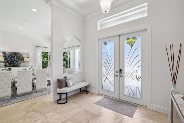 foyer entrance featuring french doors, a wealth of natural light, and crown molding