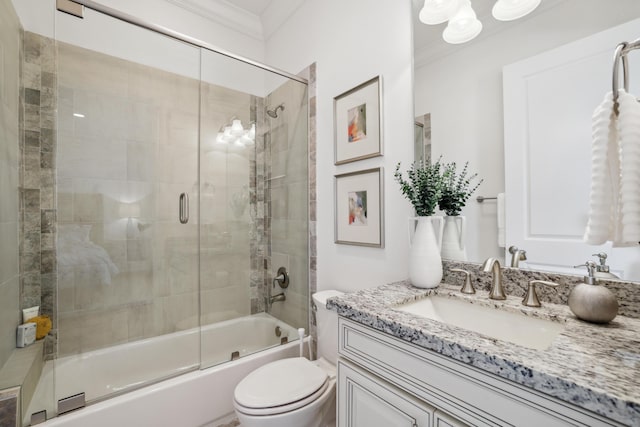 full bathroom with ornamental molding, vanity, bath / shower combo with glass door, and toilet