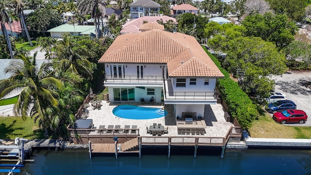 rear view of house featuring a balcony, a water view, and a patio