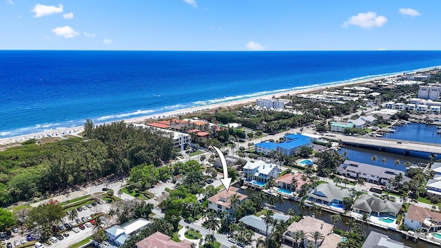 drone / aerial view featuring a water view and a view of the beach