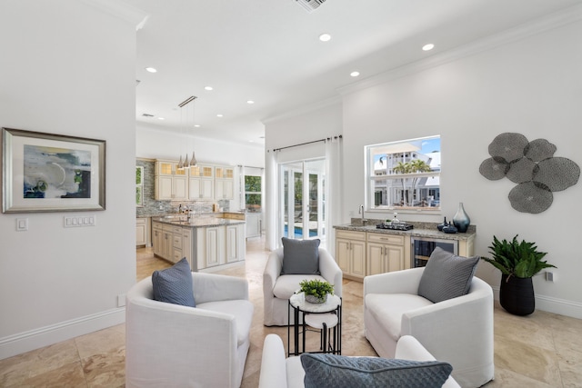 living room featuring beverage cooler, crown molding, and sink