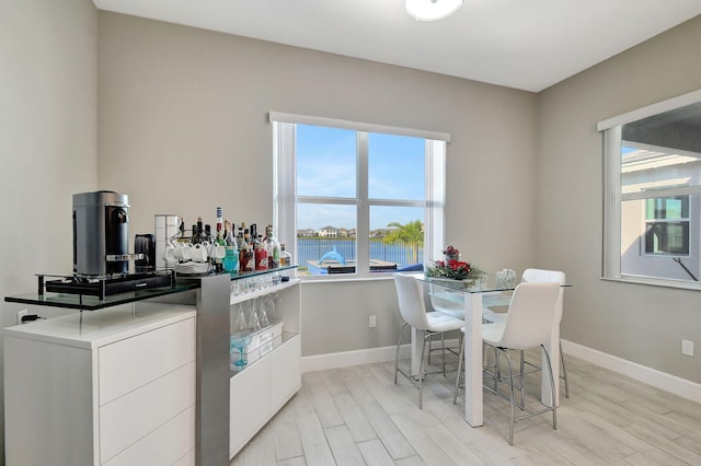 kitchen featuring white cabinetry, a water view, and light wood-type flooring