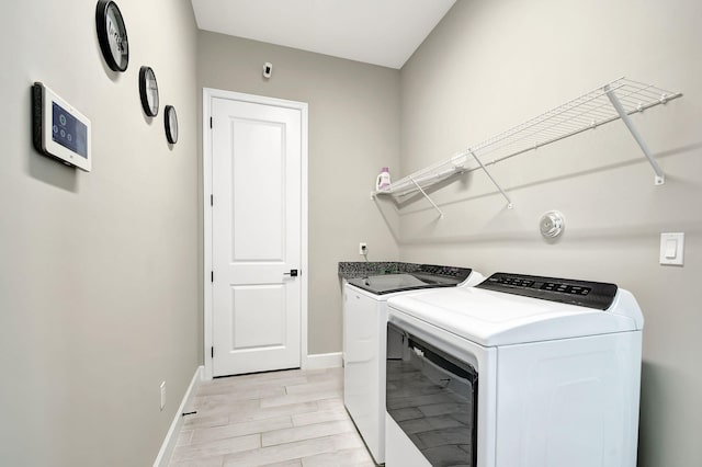 washroom featuring separate washer and dryer and light hardwood / wood-style flooring