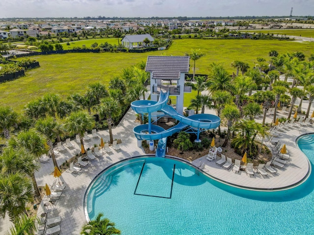 view of swimming pool featuring a pergola, a lawn, a patio, and a water slide