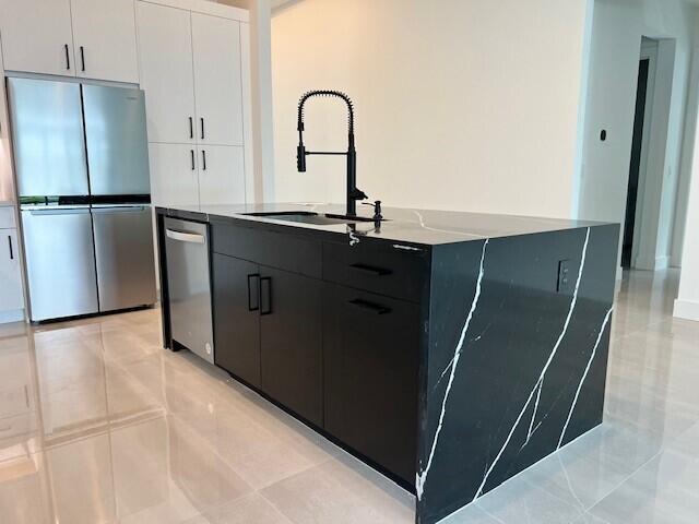 kitchen with white cabinetry, sink, a kitchen island with sink, and stainless steel appliances