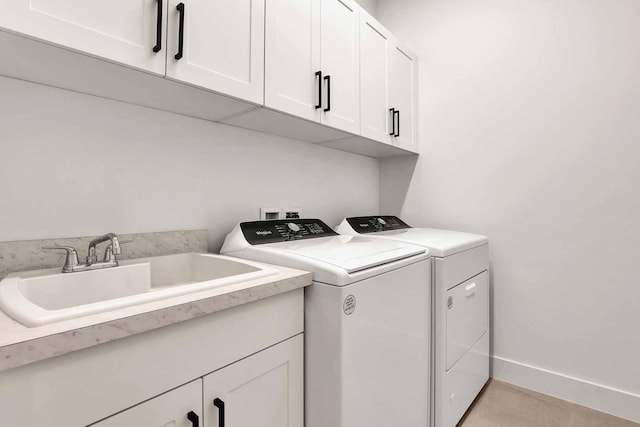 laundry area with cabinets, separate washer and dryer, and sink