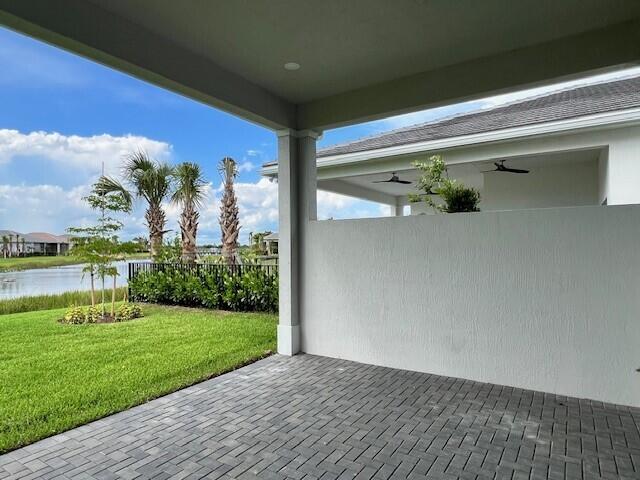 view of patio featuring a water view and ceiling fan