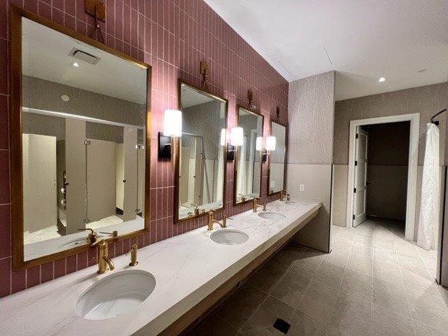 bathroom with vanity and tile walls