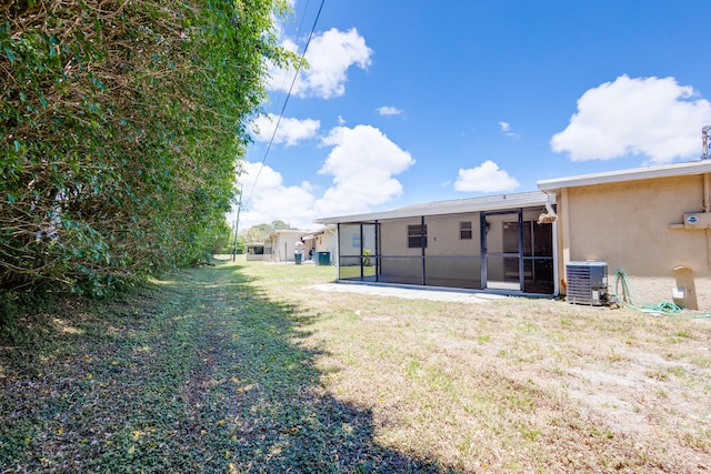 view of yard featuring central AC and a sunroom