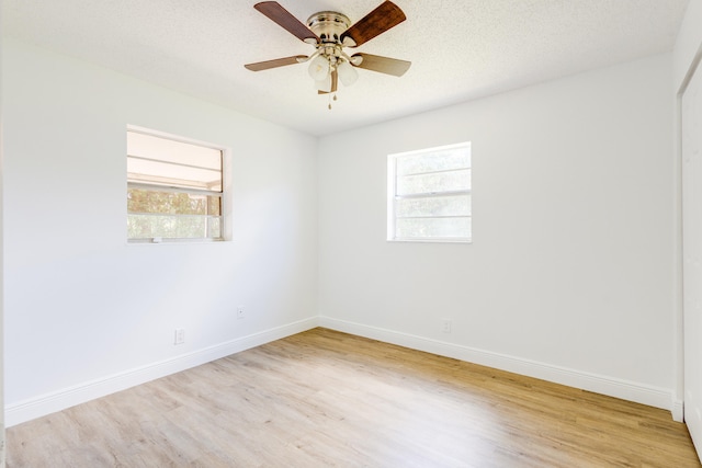 unfurnished room with light hardwood / wood-style flooring, ceiling fan, a wealth of natural light, and a textured ceiling