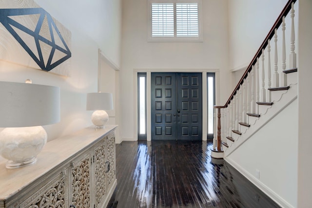 entrance foyer with dark hardwood / wood-style floors and a high ceiling