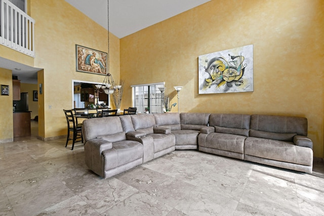 living room with a towering ceiling and a notable chandelier