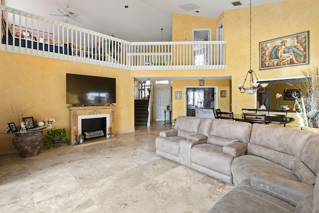 living room with ceiling fan with notable chandelier and high vaulted ceiling