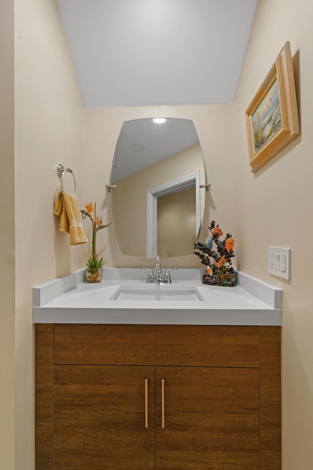 bathroom with vaulted ceiling and vanity