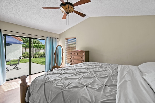 bedroom featuring light wood-type flooring, a textured ceiling, access to exterior, lofted ceiling, and ceiling fan