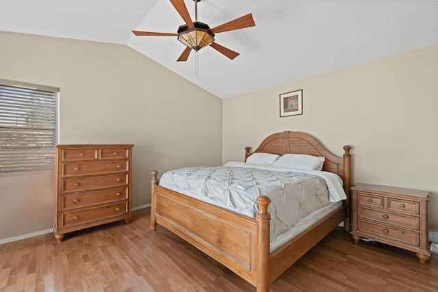 bedroom featuring a textured ceiling, lofted ceiling, hardwood / wood-style floors, and ceiling fan