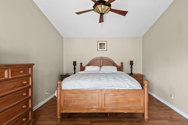 bedroom featuring ceiling fan, a textured ceiling, dark hardwood / wood-style floors, and vaulted ceiling