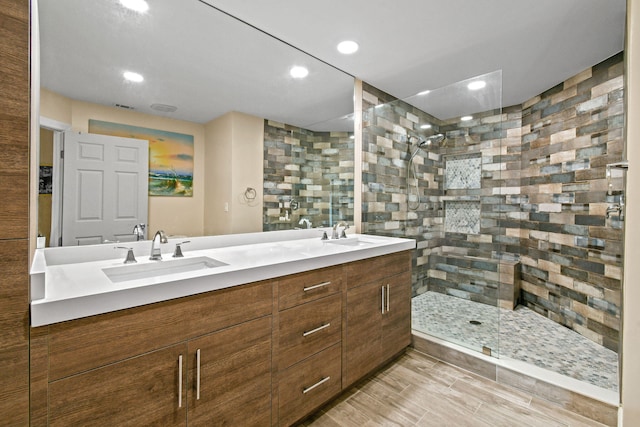 bathroom with walk in shower, wood-type flooring, and vanity