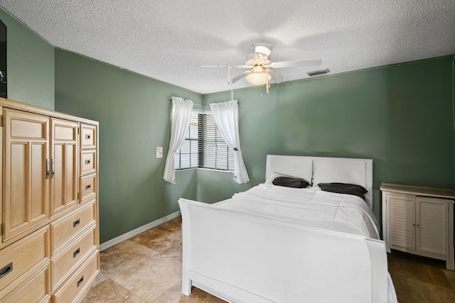 bedroom with ceiling fan and a textured ceiling