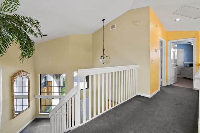 hallway featuring high vaulted ceiling and dark colored carpet