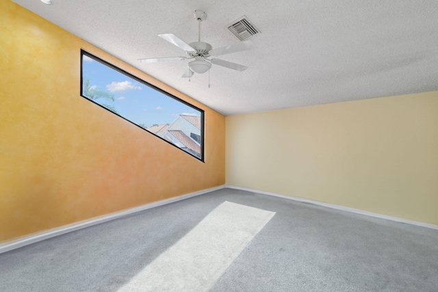 spare room featuring carpet, ceiling fan, and a textured ceiling