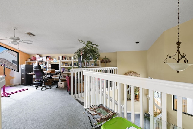 interior space featuring a textured ceiling, carpet, vaulted ceiling, and ceiling fan