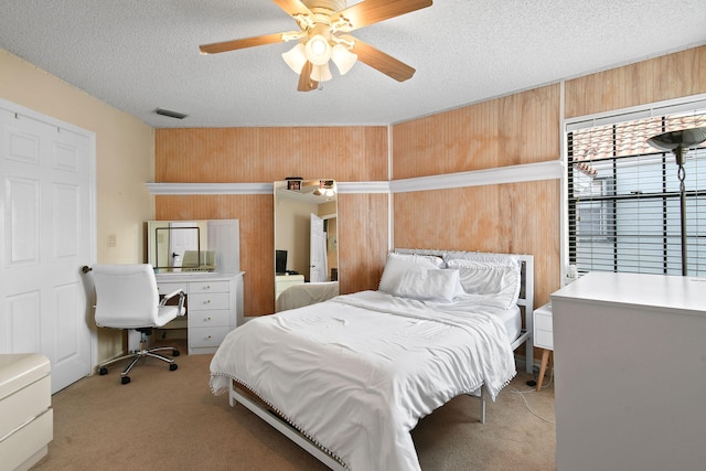 bedroom with light carpet, ceiling fan, and a textured ceiling