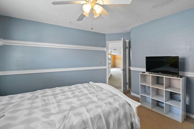 bedroom with carpet, ceiling fan, and a textured ceiling