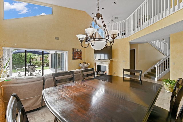 dining space featuring a notable chandelier and high vaulted ceiling