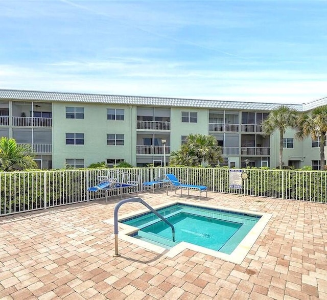 view of swimming pool with a hot tub and a patio