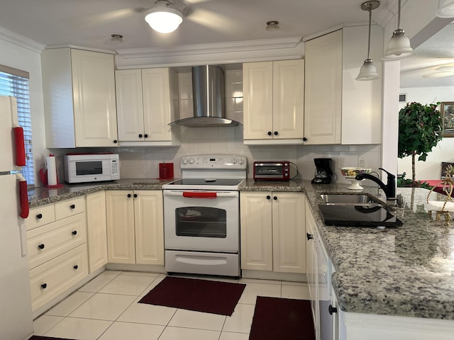 kitchen with pendant lighting, sink, white appliances, decorative backsplash, and wall chimney exhaust hood