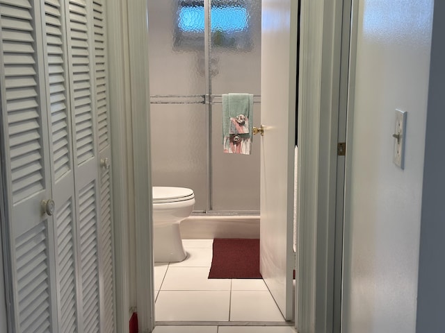 bathroom with walk in shower, tile patterned floors, and toilet