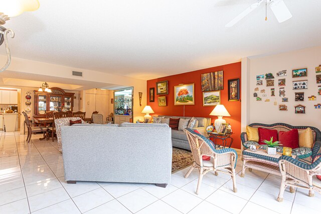 tiled living room with ceiling fan and a textured ceiling