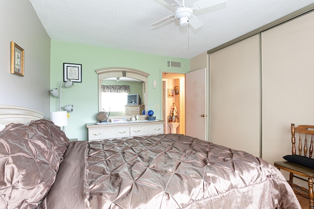 bedroom with ceiling fan, a closet, and a textured ceiling