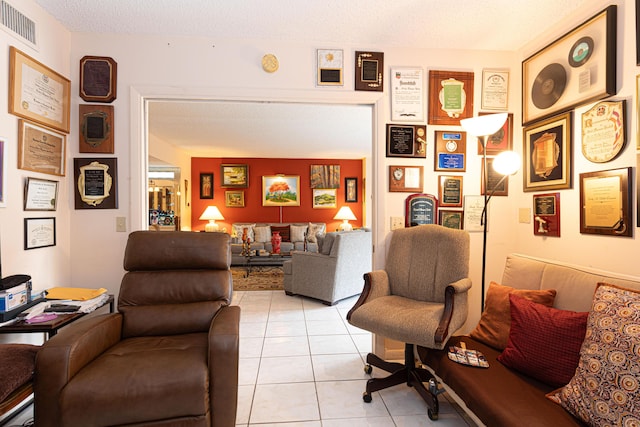 tiled living room featuring a textured ceiling